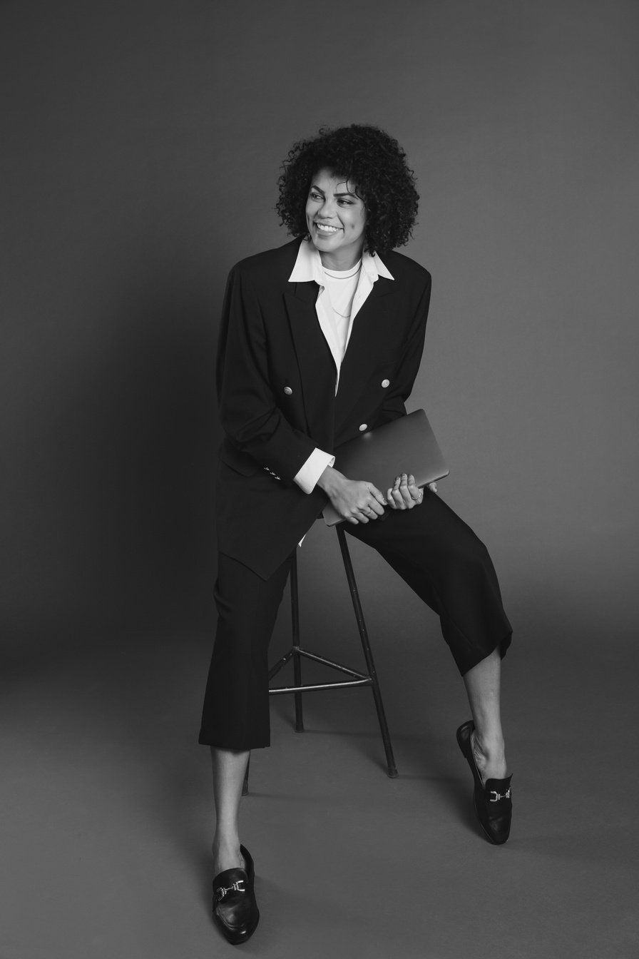 Smiling Woman Sitting on a Chair Holding a Laptop